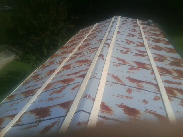 Rusted metal roof panels with new wood purlins before replacement — Storm Damage Roof Repair in Petersham by Roofing Brothers