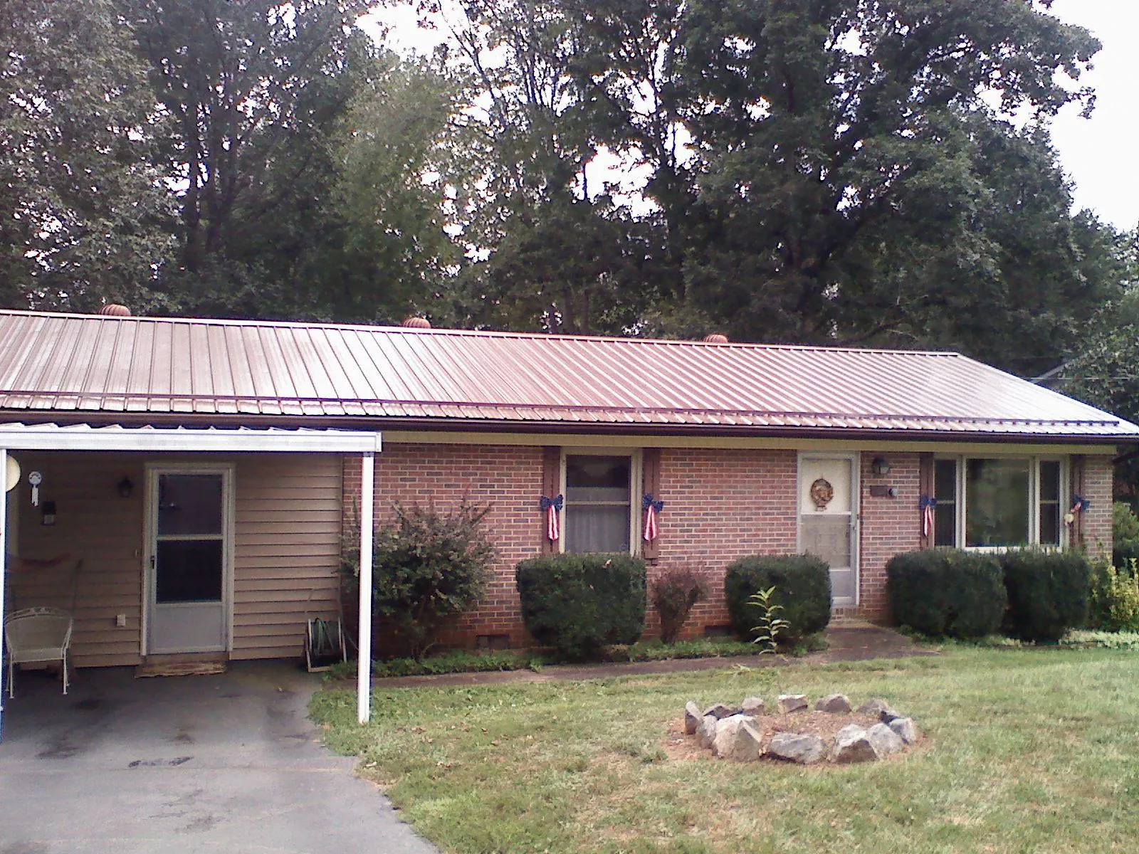 Bronze metal roof and carport on a brick ranch home — Roof Repair work by our crew in Petersham